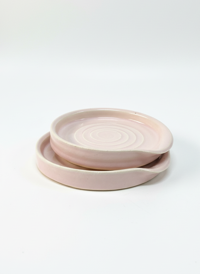 Set of pink ceramic plates on a white background