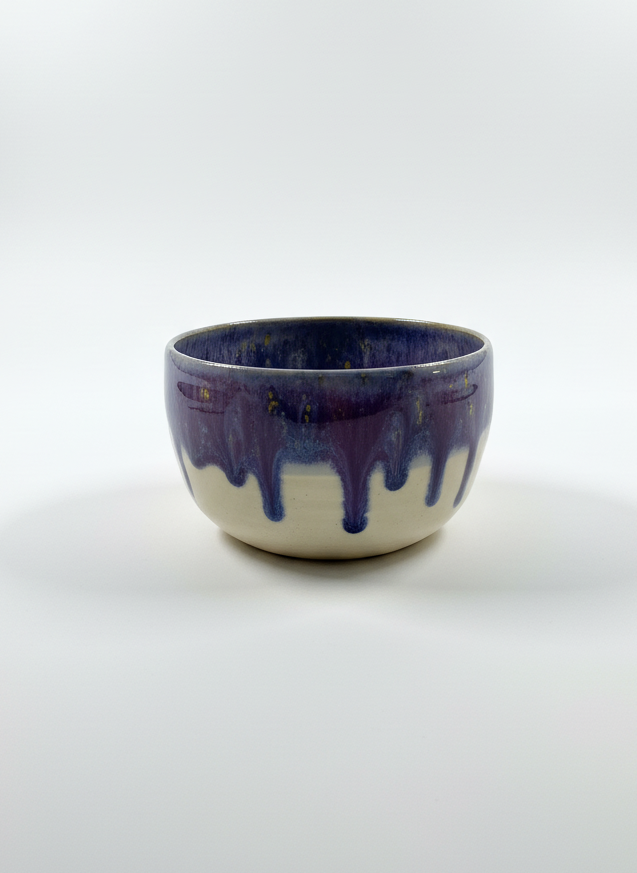 Ceramic bowl with blue and white glaze on a white background