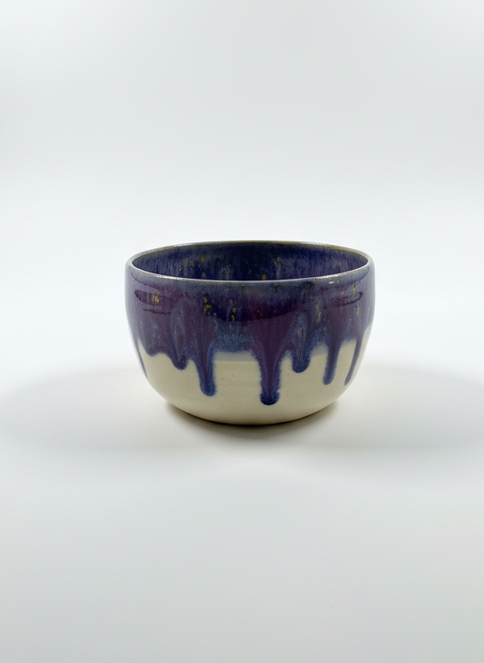 Ceramic bowl with blue and white glaze on a white background